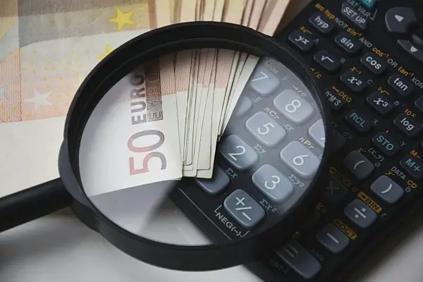 A 50 Euro banknote placed next to a black calculator for procurement purposes.